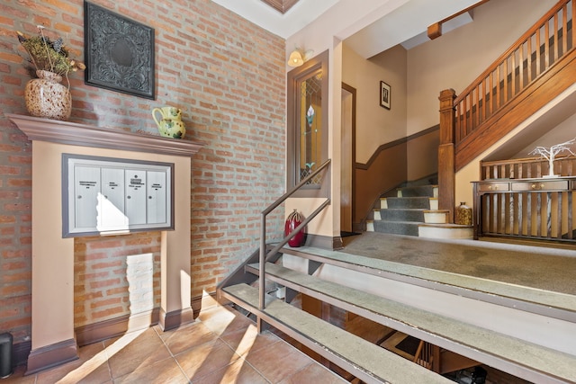 stairs featuring brick wall and tile patterned flooring