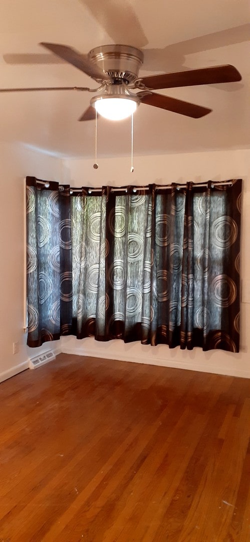 spare room with wood-type flooring and ceiling fan