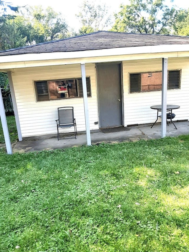 entrance to property featuring a patio and a yard