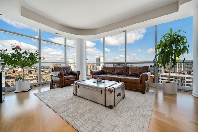 living room featuring a wall of windows and light hardwood / wood-style flooring