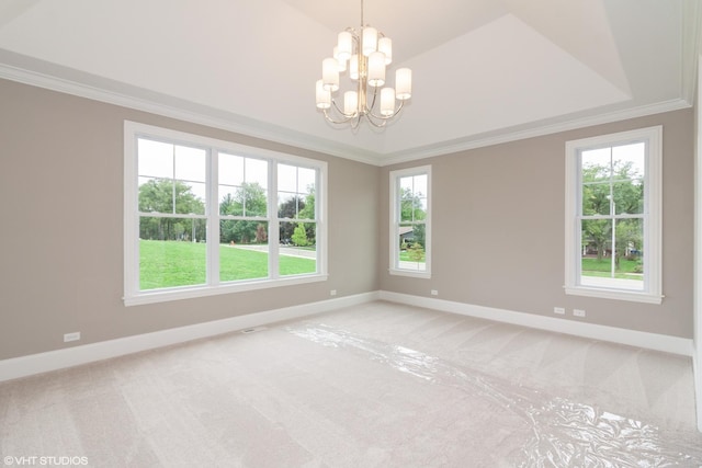 carpeted spare room featuring a wealth of natural light, vaulted ceiling, ornamental molding, and an inviting chandelier