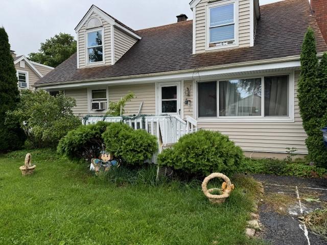 cape cod home with a front yard