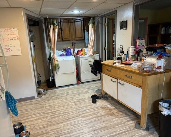 clothes washing area featuring light wood-type flooring and separate washer and dryer