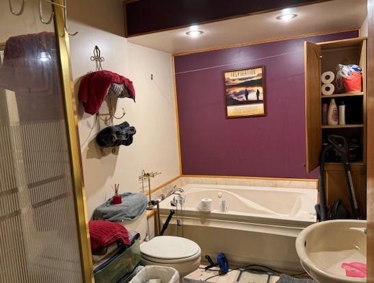 bathroom with a bathing tub, a bidet, and toilet