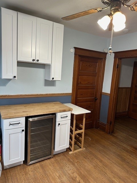 kitchen featuring light hardwood / wood-style flooring, ceiling fan, wine cooler, and white cabinets