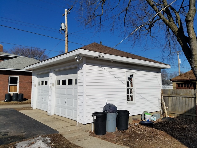 view of side of home featuring a garage and an outbuilding