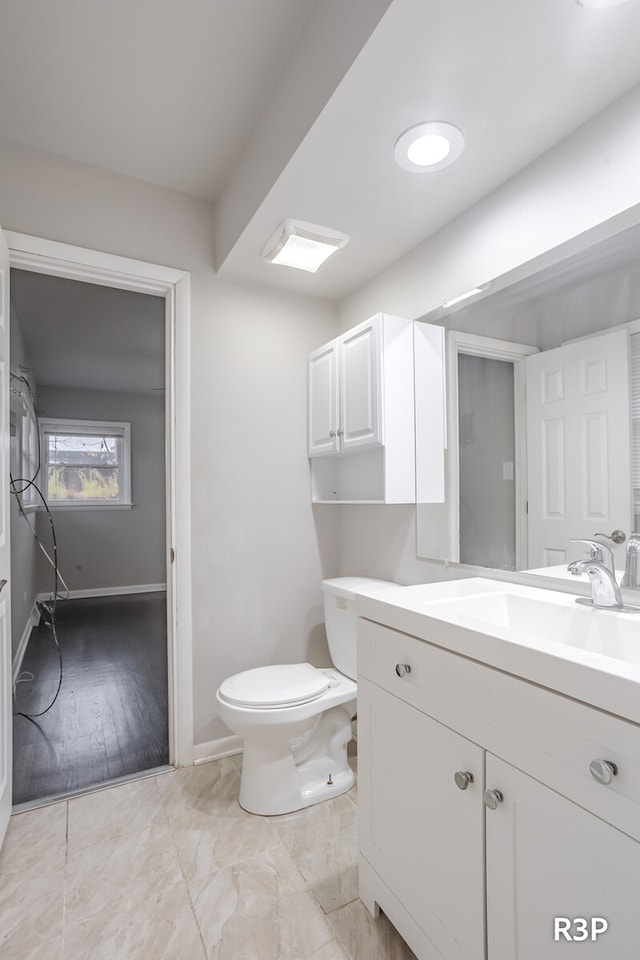 bathroom with toilet, tile patterned floors, and vanity