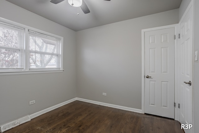 unfurnished bedroom with ceiling fan, a closet, and dark wood-type flooring