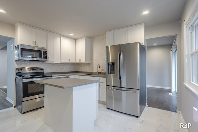 kitchen featuring stainless steel appliances, marble finish floor, and white cabinets