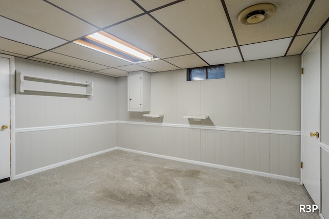 basement featuring a drop ceiling and carpet flooring