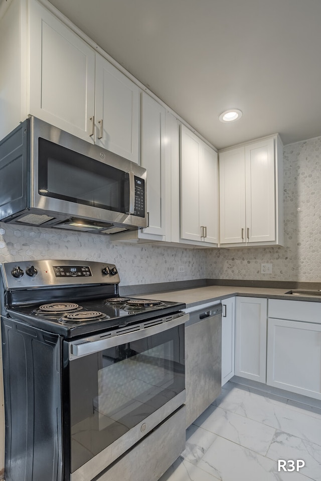 kitchen featuring white cabinets, light tile patterned flooring, and stainless steel appliances