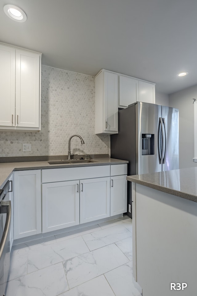 kitchen featuring white cabinetry, sink, and light tile patterned floors