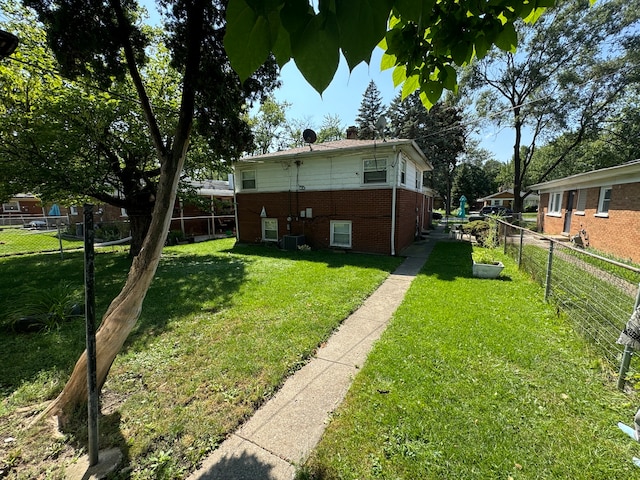 back of property featuring central air condition unit and a lawn