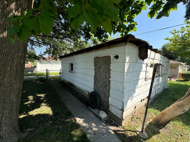 view of home's exterior with a lawn and an outdoor structure