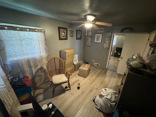 living room featuring light hardwood / wood-style floors and ceiling fan