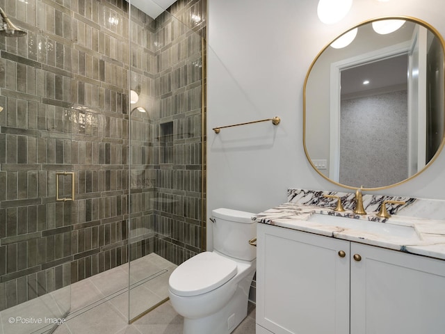 bathroom featuring tile patterned flooring, a shower with door, vanity, and toilet