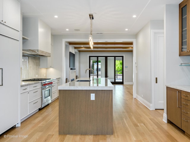 kitchen with high end appliances, light hardwood / wood-style flooring, white cabinetry, and decorative light fixtures