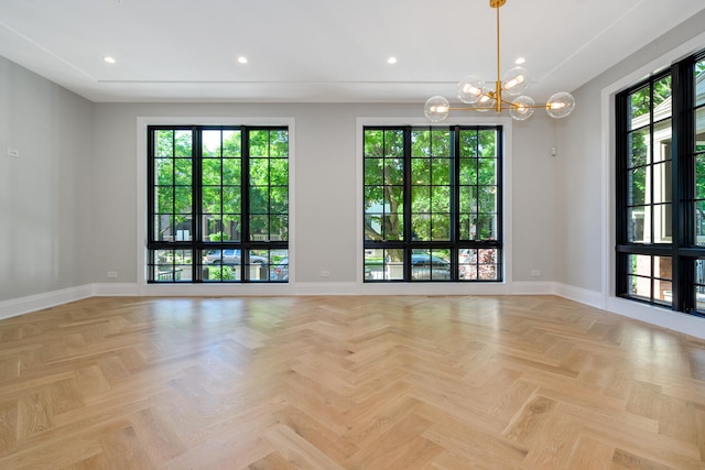 unfurnished room with a notable chandelier and light parquet floors