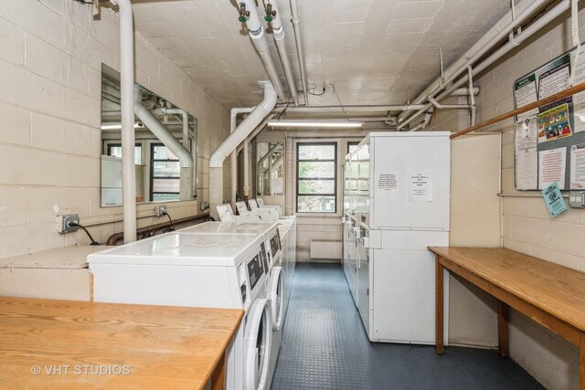 laundry area with washing machine and clothes dryer and radiator heating unit