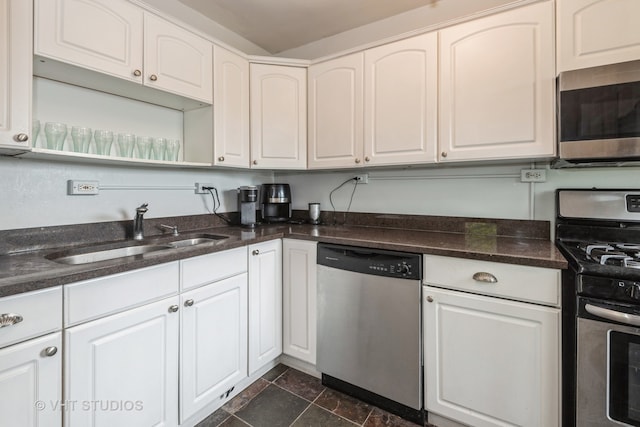 kitchen featuring white cabinets, sink, stainless steel appliances, and dark tile patterned floors