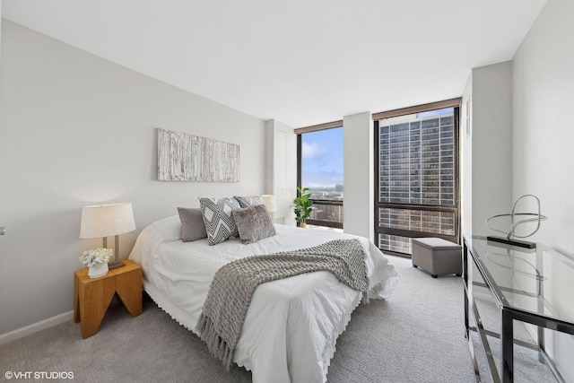 carpeted bedroom with baseboards and expansive windows