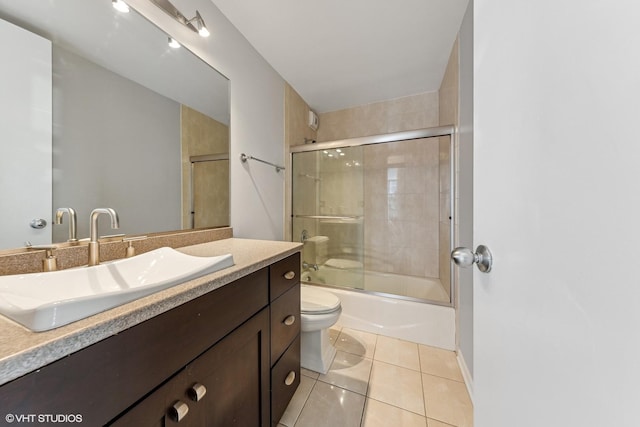 bathroom with tile patterned flooring, toilet, vanity, and shower / bath combination with glass door