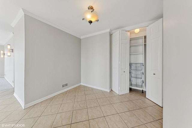 unfurnished bedroom featuring light tile patterned floors, a closet, baseboards, and ornamental molding