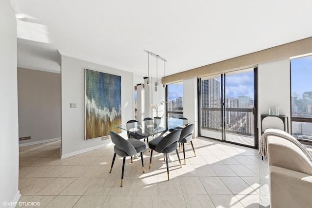 dining room featuring light tile patterned floors, a view of city, crown molding, and baseboards