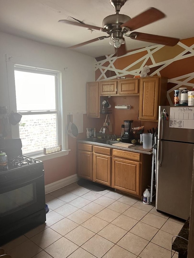 kitchen with ceiling fan, stainless steel fridge, light tile patterned floors, and black range with electric cooktop