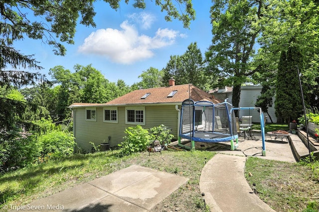 28629 W Ravine Dr, Barrington, IL 60010 - rear view of property with a fire pit, a trampoline, a patio, and a chimney