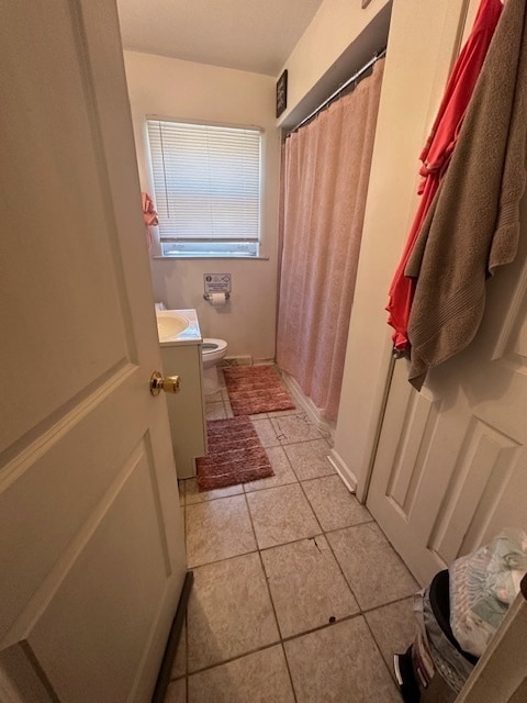 bathroom featuring toilet, vanity, and tile patterned floors