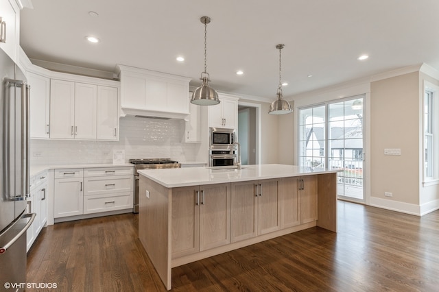 kitchen with white cabinets, dark hardwood / wood-style floors, high quality appliances, and an island with sink