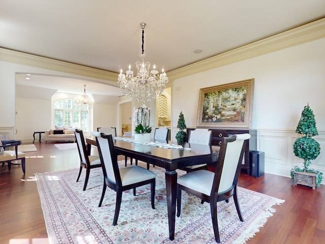 dining space featuring ornamental molding, a chandelier, and dark hardwood / wood-style floors