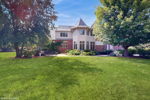 view of front of home with a patio and a front lawn