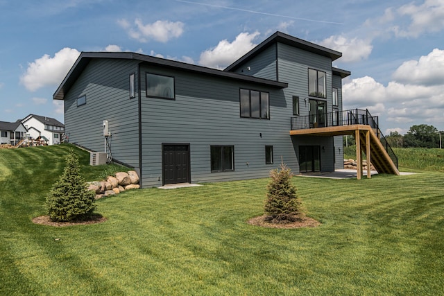 back of house with a deck and a lawn