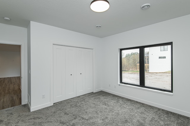 unfurnished bedroom featuring carpet and a closet