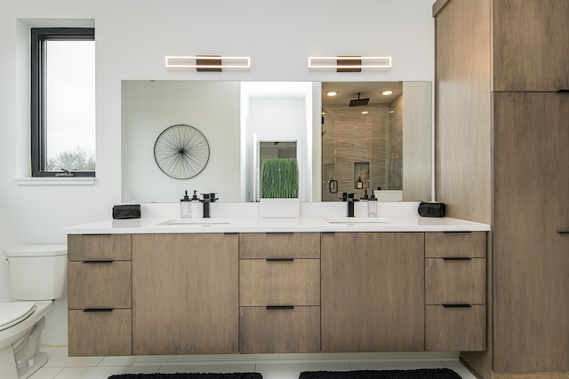 bathroom featuring double sink vanity, plenty of natural light, toilet, and tile patterned floors