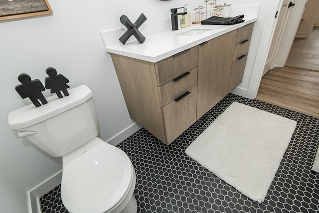 bathroom with toilet, tile patterned floors, and vanity