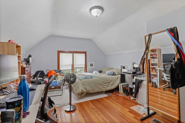 bedroom featuring wood finished floors and vaulted ceiling