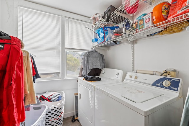 laundry area featuring baseboards, laundry area, wood finished floors, and washer and clothes dryer