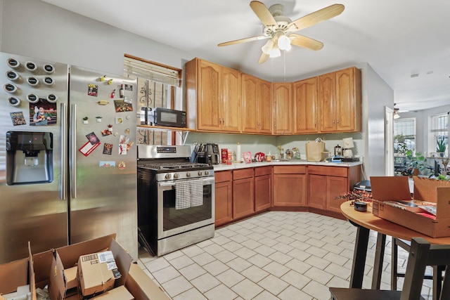 kitchen with light countertops, ceiling fan, stainless steel appliances, and tasteful backsplash