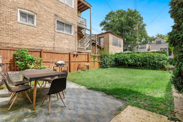 view of yard with a patio, fence, and outdoor dining space