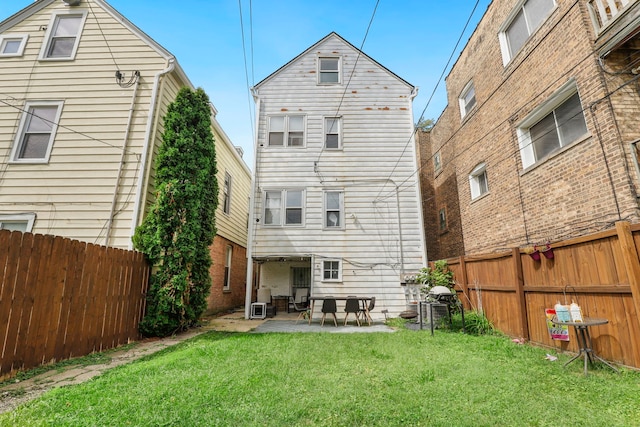 back of house with a lawn, a fenced backyard, and a patio area