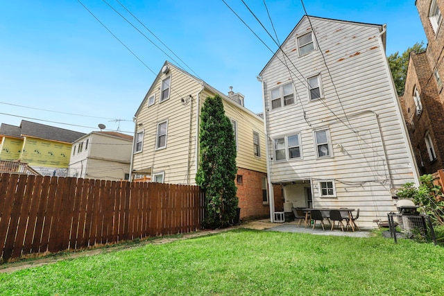 rear view of property featuring a patio area, fence, and a yard