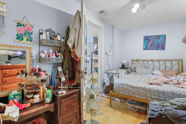 bedroom featuring wood-type flooring and visible vents