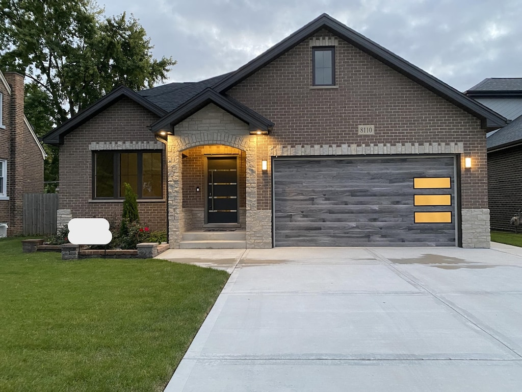 view of front of house with a garage and a front lawn