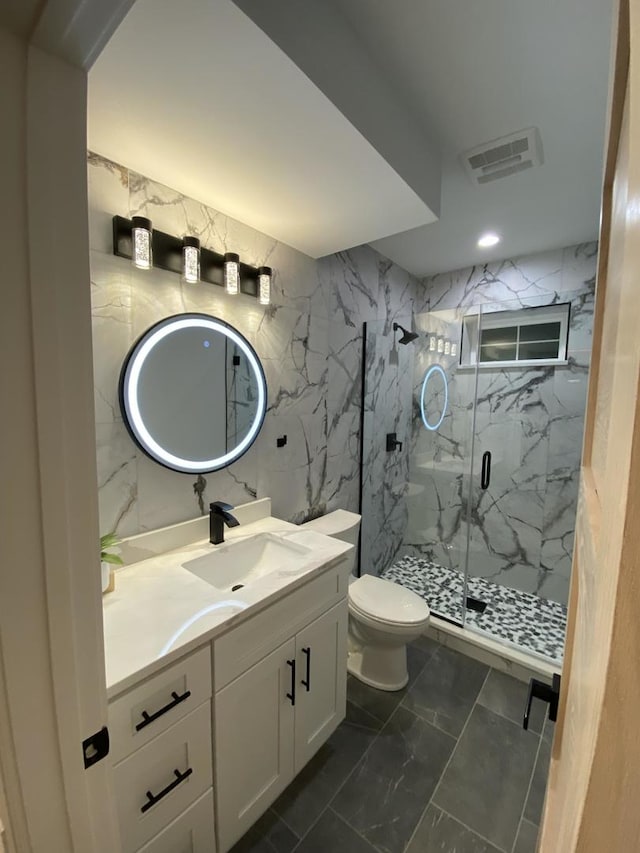 bathroom with a shower with door, toilet, vanity, and tile patterned floors