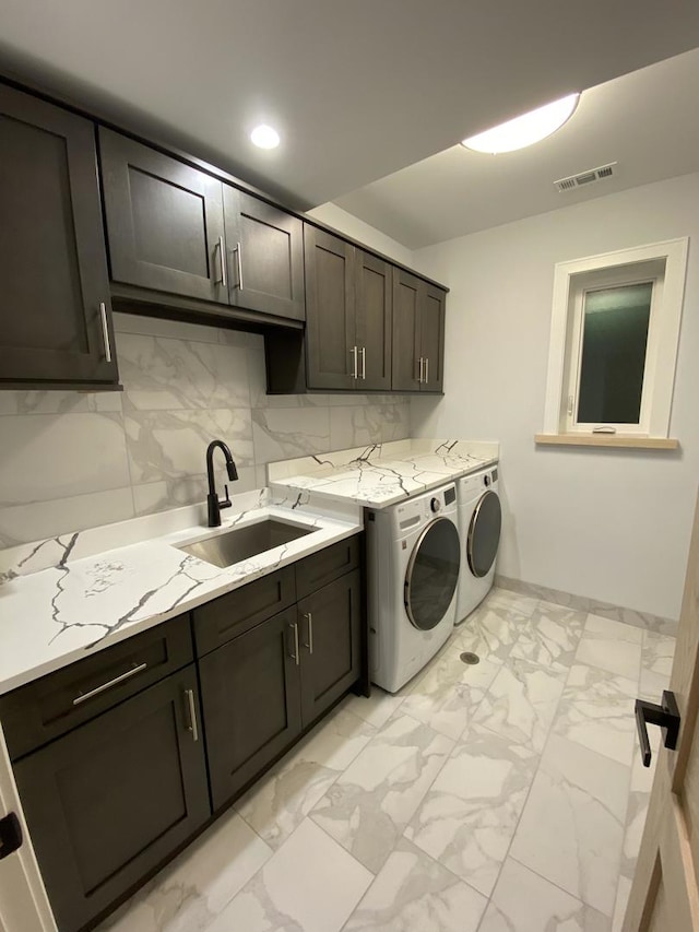 laundry area with light tile patterned floors, sink, independent washer and dryer, and cabinets