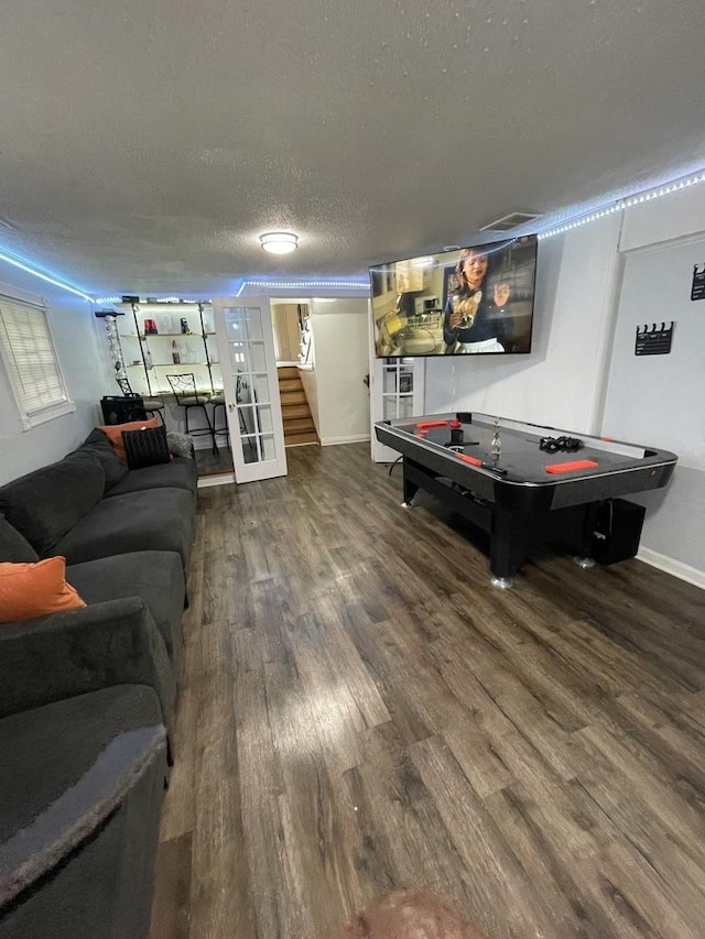 playroom featuring a textured ceiling, wood finished floors, visible vents, and baseboards