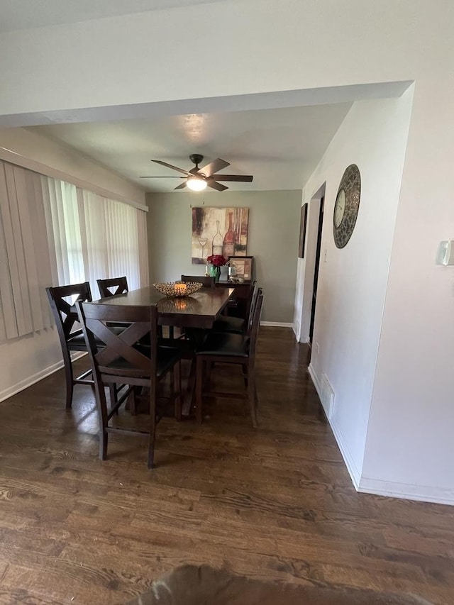 dining room featuring dark wood-style flooring, a ceiling fan, and baseboards